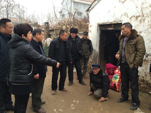 图为县残联一行与残疾人贫困户关切交谈