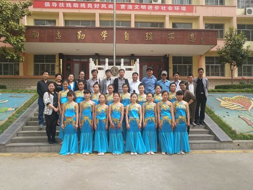 图为:洛阳市残联调研人员与新安县特教学校学生合影 图为:洛阳市残联调研人员与新安县特教学校学生合影