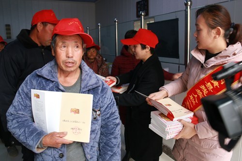 图为残联工作人员向残疾人发放书籍《养生堂》 图为残联工作人员向残疾人发放书籍《养生堂》