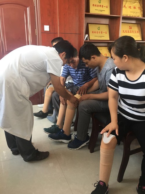 图为残疾人带上新假肢 图为残疾人带上新假肢