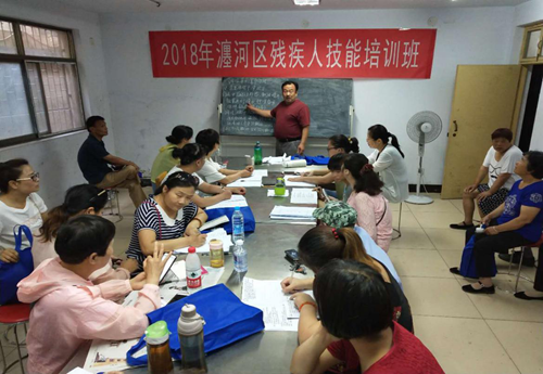 图为:残疾学员认真听培训老师授课 图为:残疾学员认真听培训老师授课
