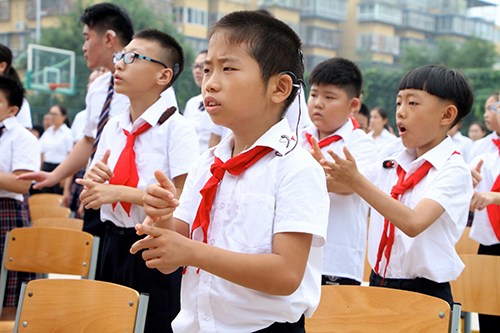 图为聋生在升国旗仪式上用国家通用手语表达国歌 图为聋生在升国旗仪式上用国家通用手语表达国歌