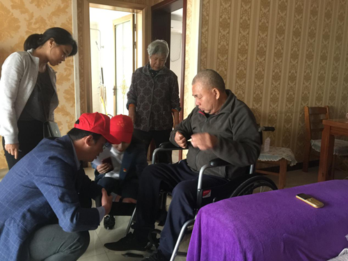 图为志愿者为残疾人安装调试轮椅 图为志愿者为残疾人安装调试轮椅