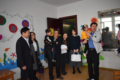 图为考核组在听力语言康复中心考察并与在训幼儿进行亲切互动 图为考核组在听力语言康复中心考察并与在训幼儿进行亲切互动