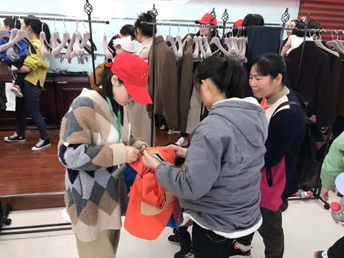 图为志愿者为残友配发服饰 图为志愿者为残友配发服饰