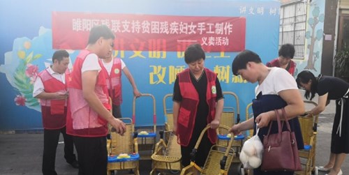 图为商丘市睢阳区残联举行“支持贫困妇女手工制作”义卖活动现场